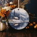 a christmas ornament with a picture of a cabin in the snow