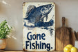 a gone fishing sign on a shelf next to lemons