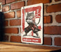 a picture of a cat on a sign on a brick wall