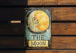 a sign that says the moon with a picture of a woman's face
