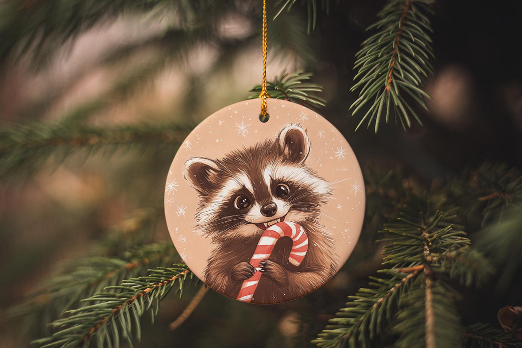a christmas ornament with a raccoon holding a candy cane