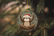 a christmas ornament with a slotty hanging from a tree