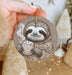 a slotty holding a cup of coffee ornament
