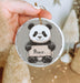 a person holding a christmas ornament with a panda on it