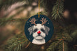 a christmas ornament with a dog wearing reindeer antlers