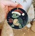 a person holding a christmas ornament with a turtle on it