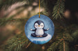 a penguin ornament hanging from a christmas tree