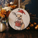 a christmas ornament with a picture of a kangaroo holding a present