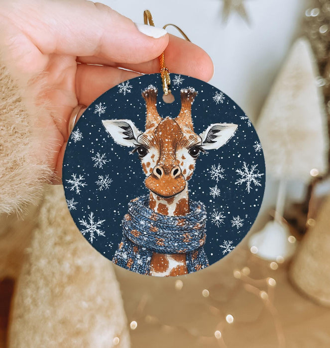 a hand holding a christmas ornament with a picture of a giraffe