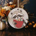 a ceramic ornament with a raccoon holding a basket