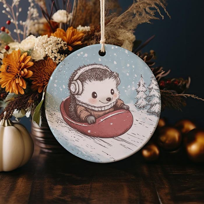 a ceramic ornament with a hedge riding a sled