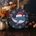 a christmas ornament with a whale wearing a santa hat