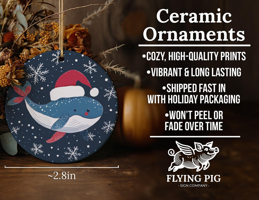 a ceramic ornament with a whale wearing a santa hat