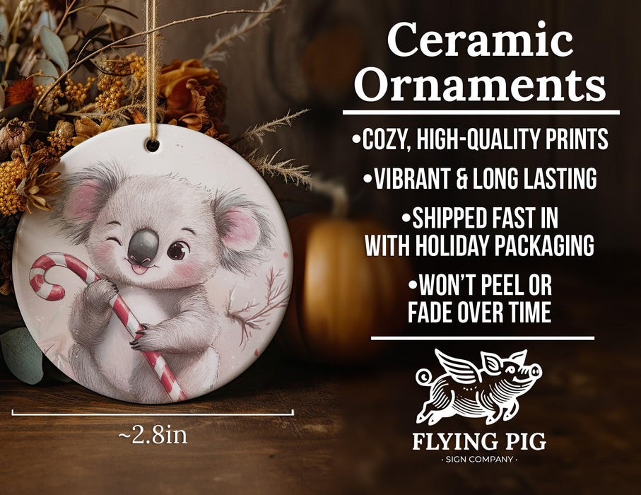 a ceramic ornament with a koala holding a candy cane