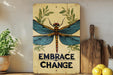 a sign that says embrace change with a dragonfly on it