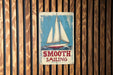 a sign on a wooden wall that says smooth sailing