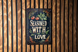 a sign on a wooden wall that says seasoned with love
