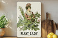 a plant lady sign on a shelf next to a potted plant