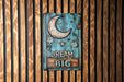 a sign on a wooden wall that says dream big