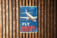 a sign on a wooden wall that says fly away