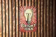 a bright idea sign on a wooden wall
