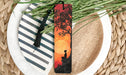 a bookmark with a picture of a man sitting under a tree