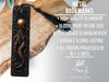 a close up of a metal bookmark on a piece of wood