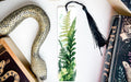 a bookmark with a picture of a plant and a snake on it