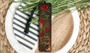 a wooden bookmark with a red rose on it