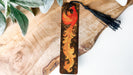 a wooden bookmark with a bird painted on it