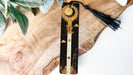 a piece of wood with a tassel hanging from it