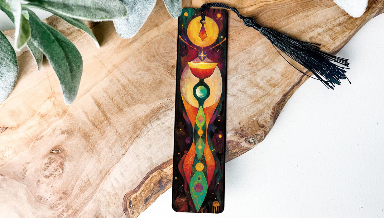 a wooden piece of art with a tassel hanging from it