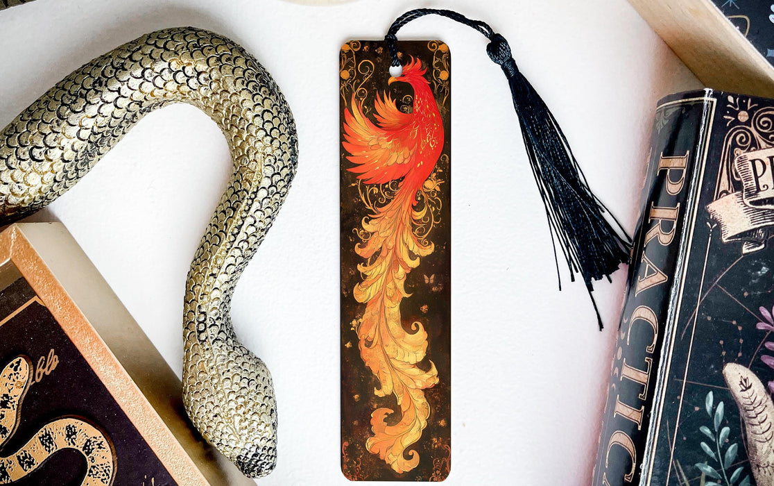 a bookmark with a dragon on it next to books