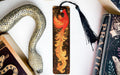 a bookmark with a dragon on it next to books
