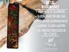a metal bookmark with a red rose on it