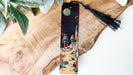 a wooden bookmark with a painting of a space scene on it