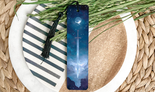 a bookmark sitting on top of a plate next to a plant