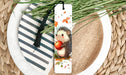 a bookmark with a hedge holding an apple