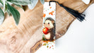 a bookmark with a hedge holding an apple
