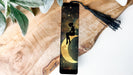 a bookmark with a picture of a girl sitting on the moon