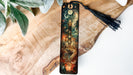 a bookmark with a tassel on top of a piece of wood