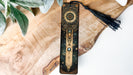 a wooden clock with a tassel hanging from it's side