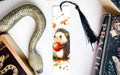 a bookmark with a hedge holding an apple