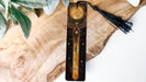 a wooden clock with a tassel hanging from it's side