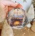 a person holding a christmas ornament in their hand