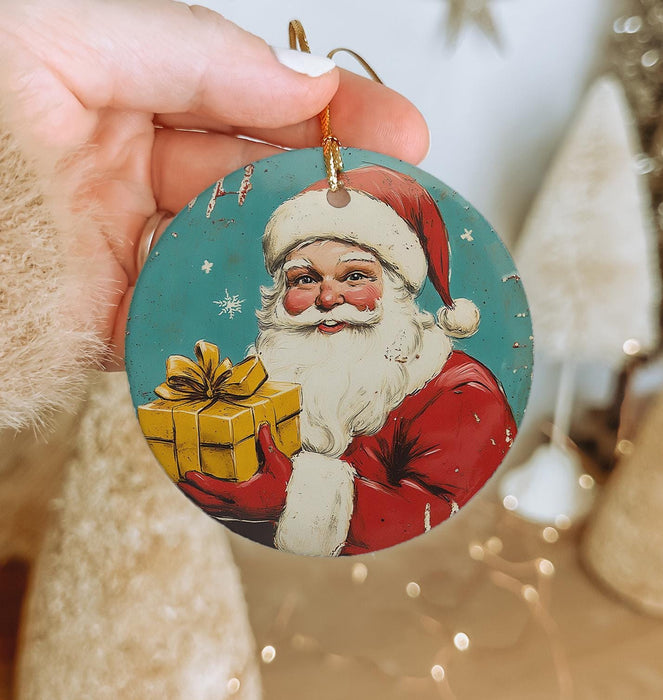 a hand holding a christmas ornament with a santa clause on it