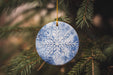 a snowflake ornament hanging from a christmas tree