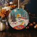 a ceramic ornament with a winter scene on it