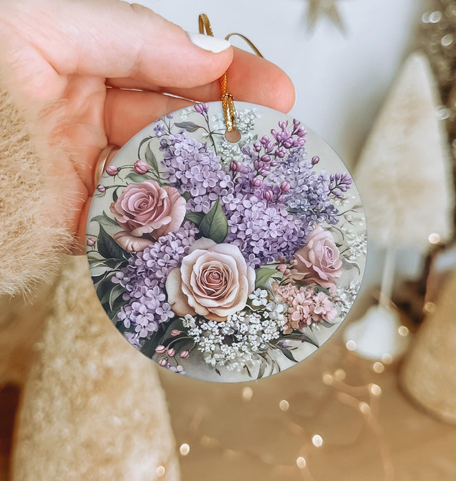 a person holding a round ornament with flowers on it