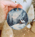 a person holding a christmas ornament in their hand